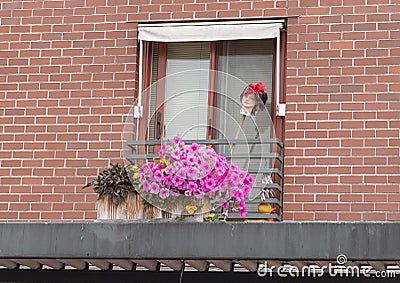 Purple flowers and a manequin head on a balcony in Pike Street Market Stock Photo