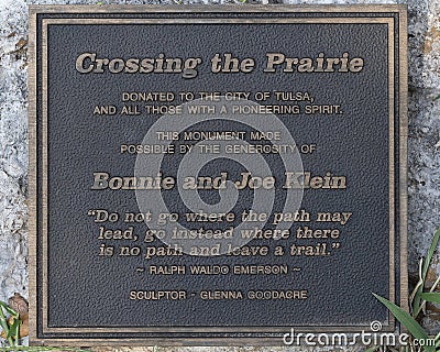 Plaque by the bronze sculpture titled Crossing the Prairie by Glenna Goodacre along the Tulsa River Trail in Oklahoma. Editorial Stock Photo