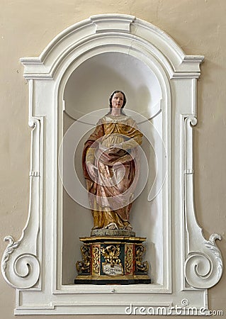 Sculpture of St. Gertrude in a niche on a side wall of the Church of St. Mary of Graces in Varenna, Italy. Editorial Stock Photo