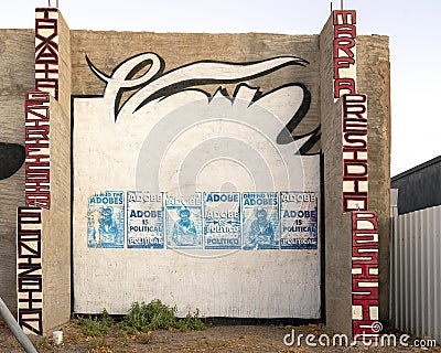 Six `Adobe is Political` posters on a painted wall in Marfa, Texas. Editorial Stock Photo