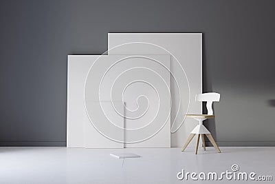 Pictures and chair in gray studio with atmospheric lighting Stock Photo