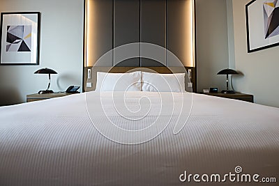 Pictures of a generic hotel room - Bed, window, table, lamps all in shot. Stock Photo