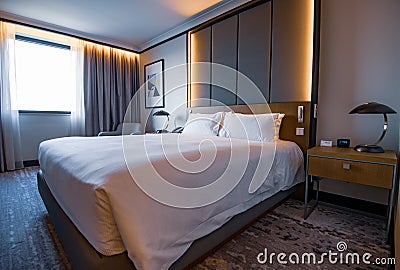 Pictures of a generic hotel room - Bed, window, table, lamps all in shot. Stock Photo