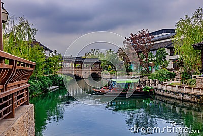 Picturesque arched bridge spanning a tranquil body of water on a cloudy day in Shanghai, China Stock Photo