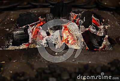 Picturesque burning bright coals smolder in a metal stand Stock Photo