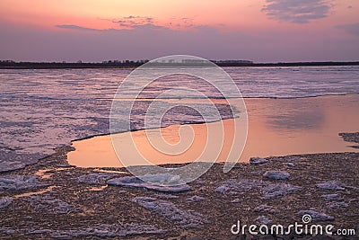Picturesque colorful ice drift on a calm wide river during the pink sunset Stock Photo
