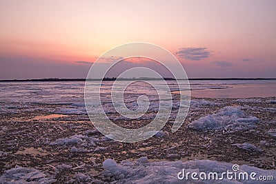 Picturesque colorful ice drift on a calm wide river during the pink sunset Stock Photo