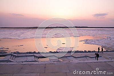 Picturesque colorful ice drift on a calm wide river during the pink sunset with pink reflection on water Stock Photo