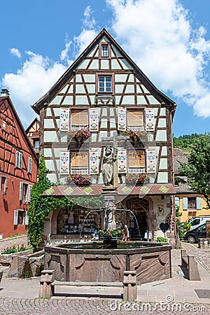 picturesque colorful street of half-timber buildings with fountain in front in the village of Kaysersberg in Vosges region Editorial Stock Photo