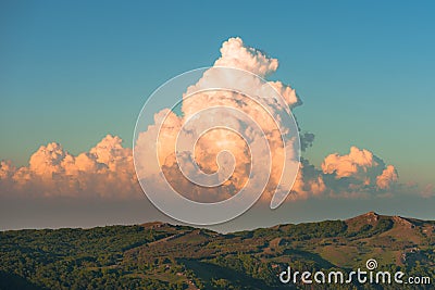 Picturesque cumulus storm cloud in the sky. Sunset colors. Stock Photo