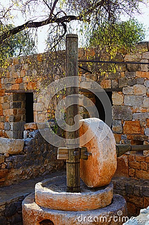 Picturesque landscape view ruins of antique building with stone wheel for squeezing juice from olives Stock Photo