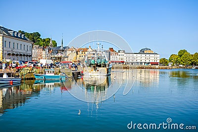 The picturesque port harbour at Honfleur France, on the coast of Normandy, with a fishing boat, smaller boats, and seagulls Editorial Stock Photo