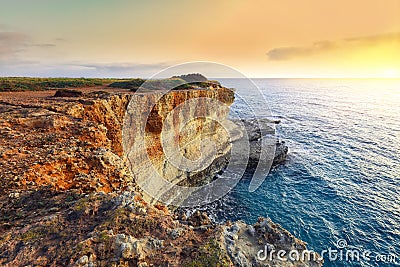 Picturesque seascape with cliffs rocky arch and stacks faraglioni at Torre Sant Andrea Stock Photo