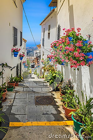Picturesque street of Mijas with flower pots in facades. Andalusian white village. Costa del Sol. Southern Spain Stock Photo