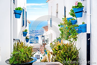 Picturesque street of Mijas with flower pots in facades Stock Photo