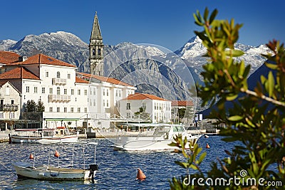 Picturesque view of ancient city of Perast, Montenegro. Boy in old medieval little town with red roofs and majestic mountains on Stock Photo