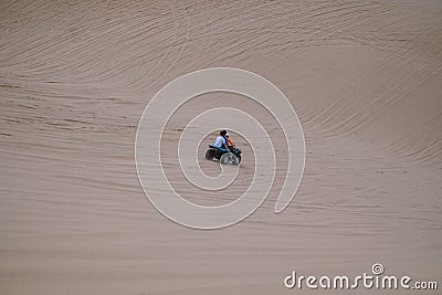 Picturesque view of ATV driving on sandy dunes and tire tracks on sand Stock Photo