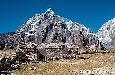 Picturesque view authentic tibetan habitation and stone fence in the Khumbu region in Nepal with majestic Taboche mountain 6501m Stock Photo