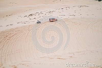 Picturesque view of big car driving on sandy dunes and tire tracks on sand Stock Photo