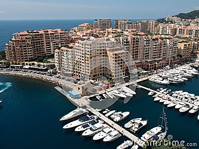 boats docked in harbor with large buildings and apartment complexes on edge Editorial Stock Photo