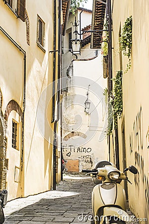 Picturesque yellow Tuscan street with a yellow scooter. Arezzo, Tuscany , Italy Stock Photo