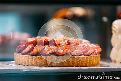 pie with strawberries, assortment baked pastry in bakery. Various Different Types Of Sweet Cakes In Pastry Shop Glass Stock Photo