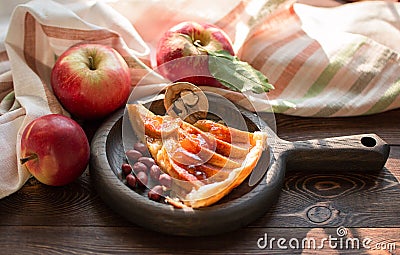 A piece of apple pie with roasted peanuts, fresh apple and caramel sauce on a plate Stock Photo