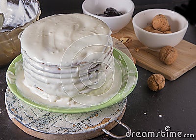 piece baked cakes for homemade honey cake are pouring white butter cream Stock Photo