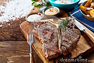 Piece of barbecued t-bone steak on wooden board Stock Photo