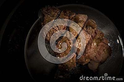 Piece of beef tenderloin to be cut into black dish Stock Photo