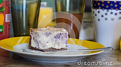 Piece of blueberry pie on a plate, glasses in the background Stock Photo