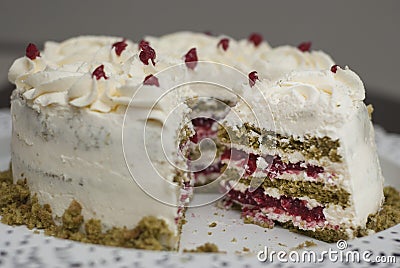 Piece of Colorful Matcha Strawbery Cake with white cream and Green Tea, on Black Plate. Unique Homemade Cake Recipe. Stock Photo