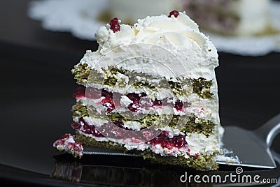 Piece of Colorful Strawbery Cake with white cream and Green Tea, on Black Plate. Unique Homemade Cake Recipe. Stock Photo