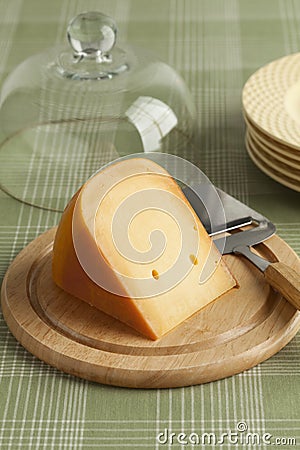 Piece of Dutch Gouda cheese on a wooden board Stock Photo