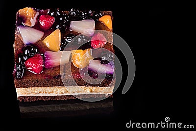 Piece of fruit cake with jelly and cream. Black background. Top view Stock Photo