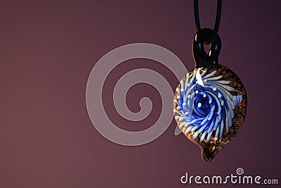 Piece of glass jewellery against a purple backdrop Stock Photo