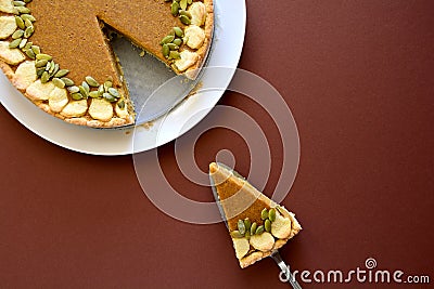 Piece of homemade pumpkin pie with cinnamon on brown paper background Stock Photo