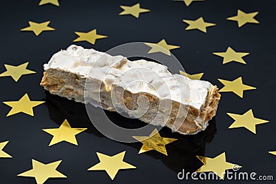 Piece of nougat (turrÃ³n) on a black surface with golden stars Stock Photo