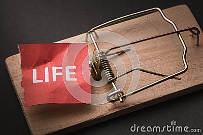 A piece of paper with text in a mousetrap. Concept on the topic of complex life in modern society Stock Photo