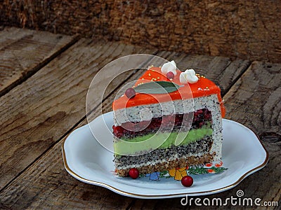 Piece of poppy cake with lime cream and strawberry jelly, covered with a mirror coating. selective focus. Stock Photo