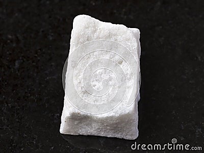 piece of rough white marble stone on dark Stock Photo