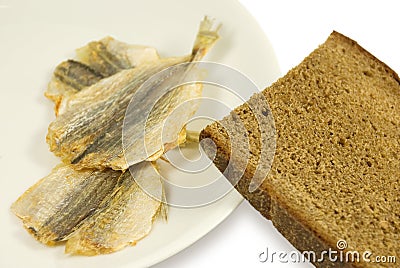 Piece of rye bread and three dried small fishes Stock Photo