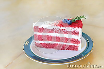 Piece of sliced red velvet cake in ceramic plate on marble table Stock Photo