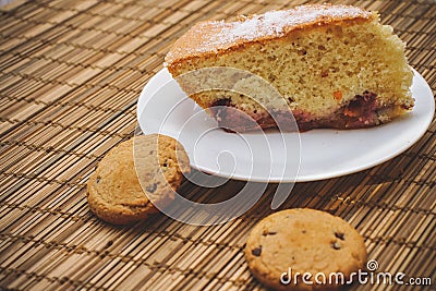 A piece of sponge cake On a round white plate with chocolate bis Stock Photo