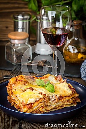 Piece of tasty hot lasagna with red wine. Stock Photo