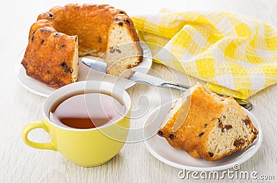 Piece of Viennese cake in plate, yellow napkin, cup of tea Stock Photo