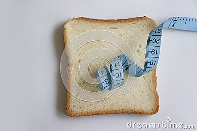 Piece of white bread measuring tape natural a light background Stock Photo