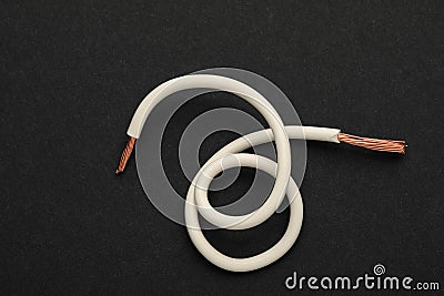 Piece of white electrical wire on black background, top view Stock Photo