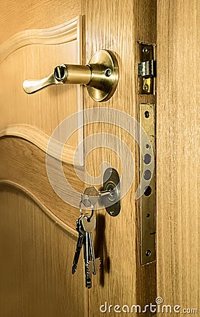 Piece of wood of an oak door with a handle and a bunch of keys Stock Photo