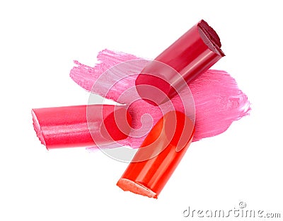 Pieces of color lipsticks on a pink lipstick smear, on white background Stock Photo